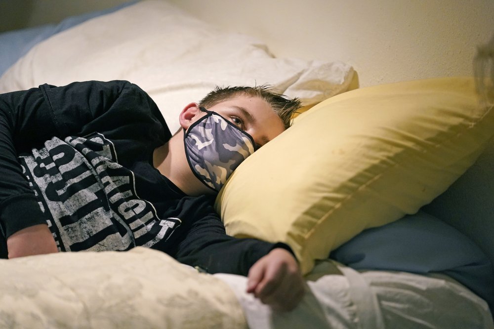 Cooper Wuthrich rests as he lays on a bed at the truck stop his family partly owns Tuesday, Dec. 15, 2020, in Montpelier, Idaho. Shortly after Thanksgiving, Wuthrich, 12, became one of hundreds of children in the U.S. diagnosed with a rare COVID-19 complication that landed him in an emergency room three hours away from his tiny hometown in a secluded Idaho valley. The boy's parents say he nearly died and their terrifying experience shows why people should wear masks in a conservative state where pushback can be fierce. CREDIT: Rick Bowmer