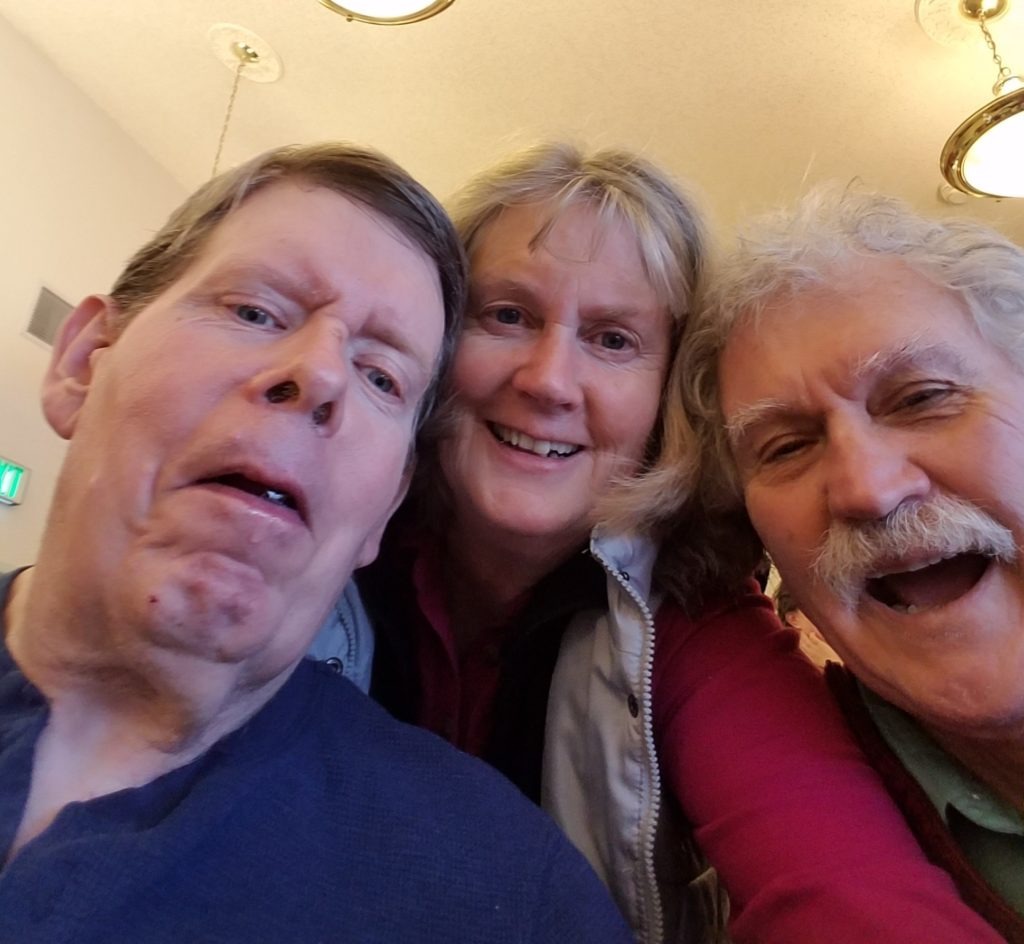 Ken Roberts, left, with his step-sister Debbie Roberts and her husband Steve Kinzie at a Christmas gathering at the Tonasket care facility in 2018. Courtesy of Debbie Roberts
