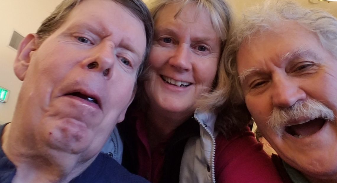 Ken Roberts, left, with his step-sister Debbie Roberts and her husband Steve Kinzie at a Christmas gathering at the Tonasket care facility in 2018. Courtesy of Debbie Roberts