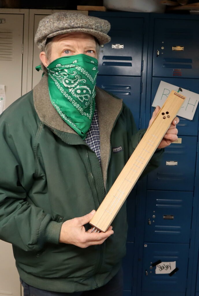 Michael Rohde shows a hummel he made from wood salvaged from a donated piano. A hummel is an old style of Northern European stringed instrument.