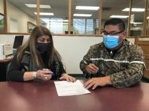 Nez Perce Tribal Executive Committee Chairman Shannon Wheeler (right) and Secretary Rachel Edwards sign paperwork completing the purchase of 148 acres of the tribe's ancestral land in eastern Oregon. Courtesy of the Nez Perce Tribe