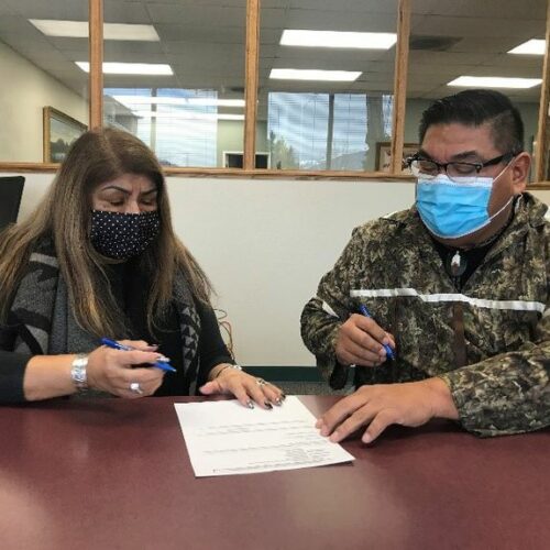 Nez Perce Tribal Executive Committee Chairman Shannon Wheeler (right) and Secretary Rachel Edwards sign paperwork completing the purchase of 148 acres of the tribe's ancestral land in eastern Oregon. Courtesy of the Nez Perce Tribe