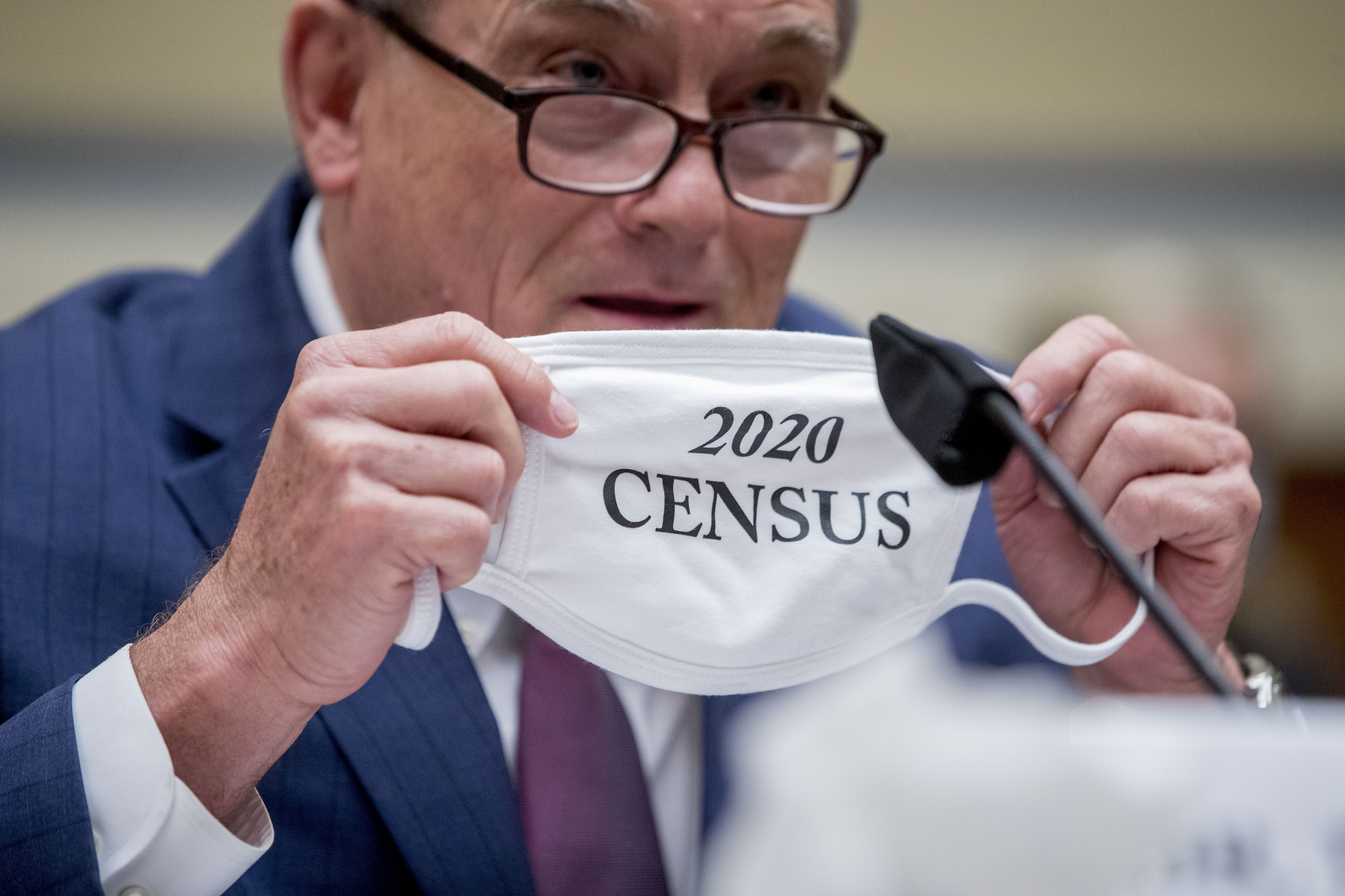 Census Bureau Director Steven Dillingham holds up his mask with the words "2020 Census" as he testifies before a House Committee on Oversight and Reform hearing on the census in July. CREDIT: Andrew Harnik/AP
