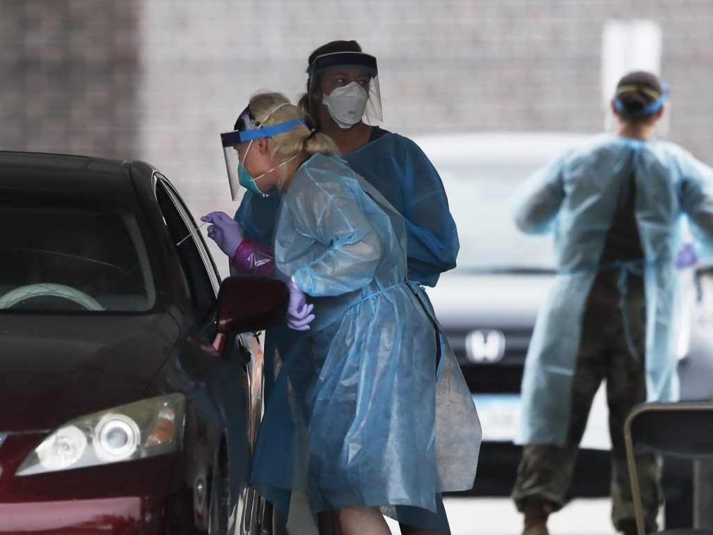 A health worker performs a coronavirus test at a Test Iowa site in Waukee, Iowa. Charlie Neibergall/AP