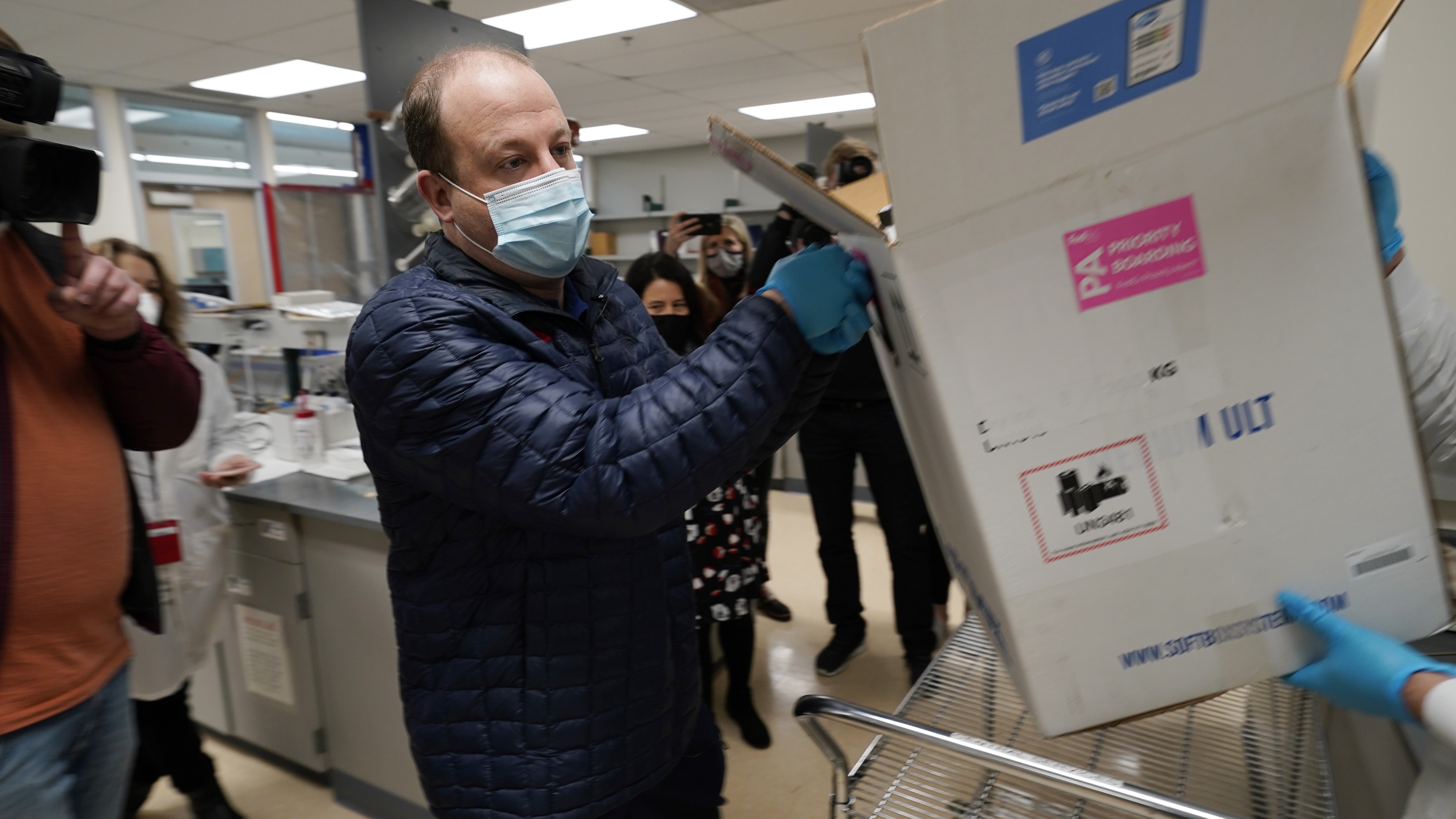 Governor of Colorado Jared Polis helps in a vaccine delivery effort