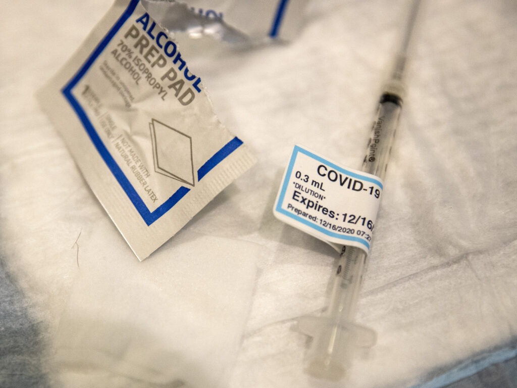 An empty syringe on a table at Ronald Reagan UCLA Medical Center after a care worker received the COVID-19 vaccine on Dec. 16, 2020. CREDIT: Brian van der Brug/AP
