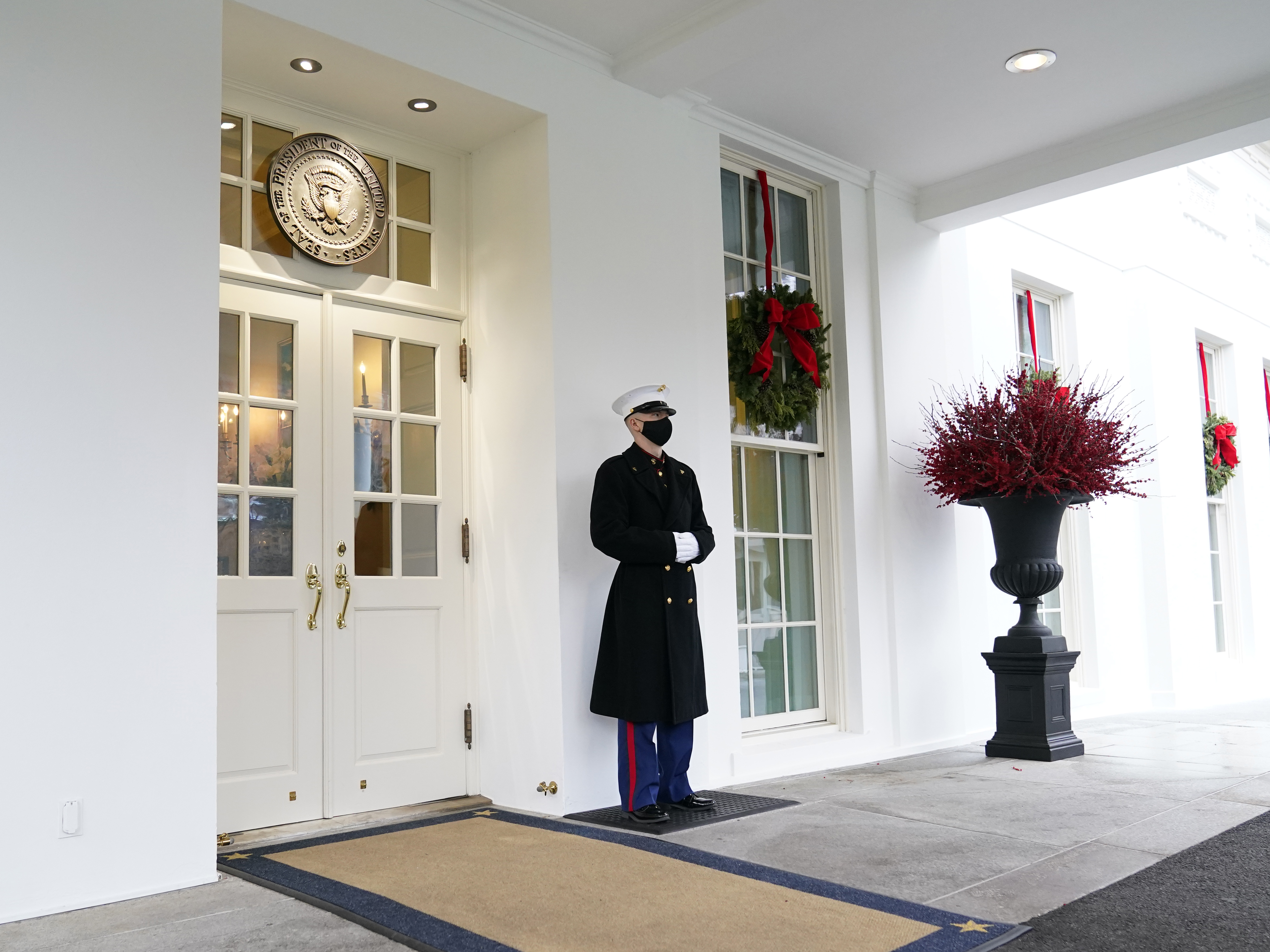 A marine stands outside the West Wing of the White House earlier this week. President Trump has been lobbied by advocates to use his powers to grant pardons and commutations ahead of leaving office. CREDIT: Susan Walsh/AP