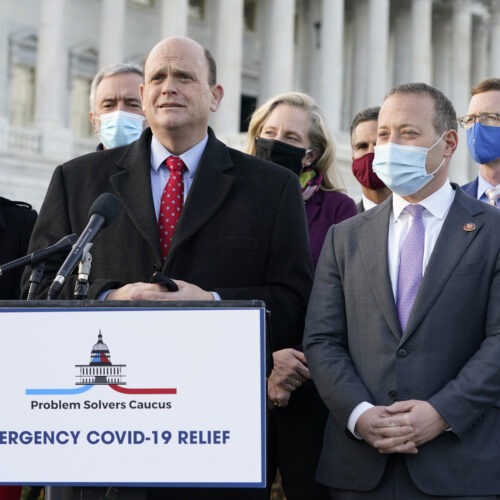 Members of the bipartisan Problem Solvers Caucus — co-chairs Rep. Tom Reed, R-N.Y., at podium, and Rep. Josh Gottheimer, D-N.J., right — took credit for helping to break the logjam on an emergency COVID-19 relief bill. CREDIT: Jacquelyn Martin/AP