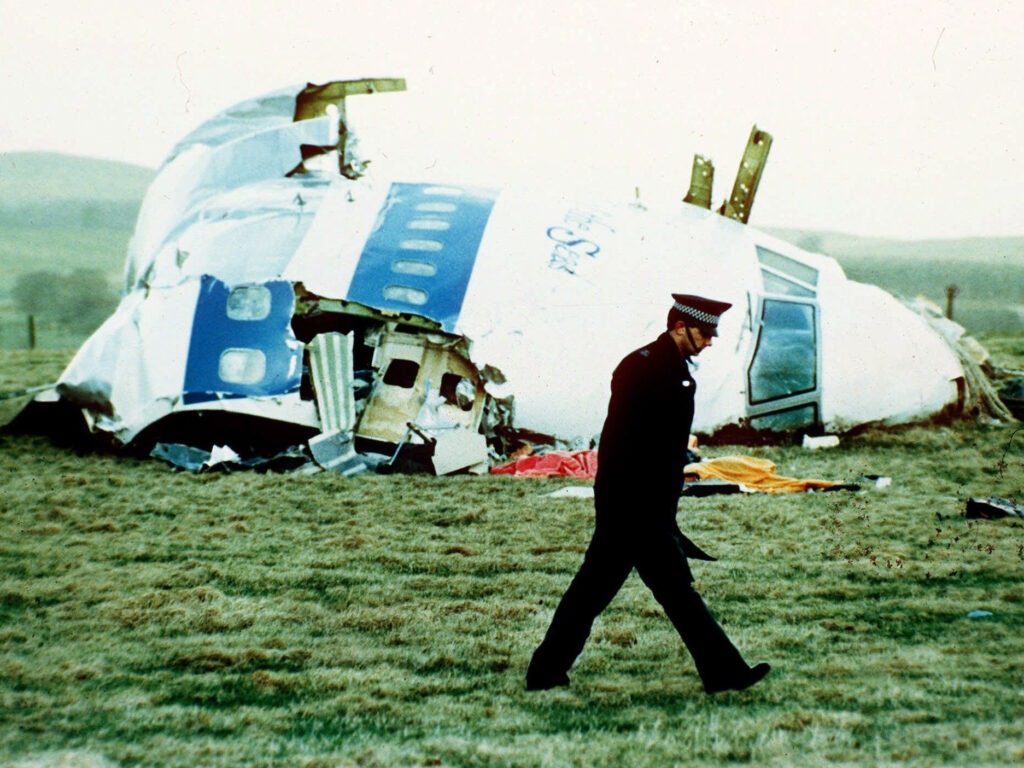 A police officer walks on Dec. 21, 1988, by the nose of Pan Am Flight 103 near Lockerbie, Scotland, where it lay after a bomb aboard exploded, killing a total of 270 people. CREDIT: Martin Cleaver/AP