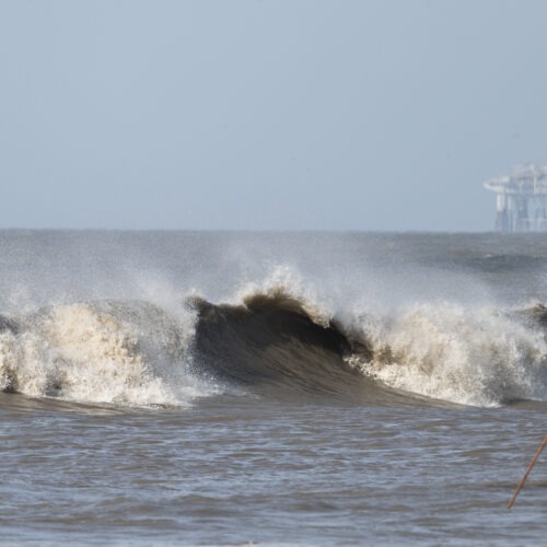 Hurricane Laura sends large waves crashing on a beach in Cameron, La., on Aug. 26 as an offshore oil rig appears in the distance. The most active hurricane season on record was just one of many challenges facing the oil industry this year — aside from the attention-grabbing crisis of the pandemic. CREDIT: Andrew Caballero-Reynolds/AFP via Getty Images