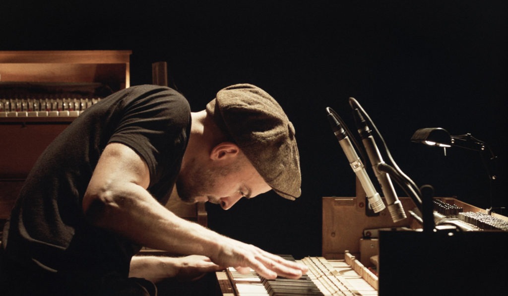 Neo classical composer Nils Frahm on stage playing piano
