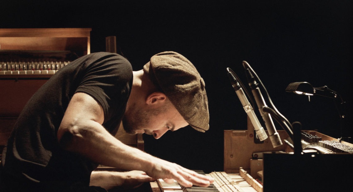 Neo classical composer Nils Frahm on stage playing piano
