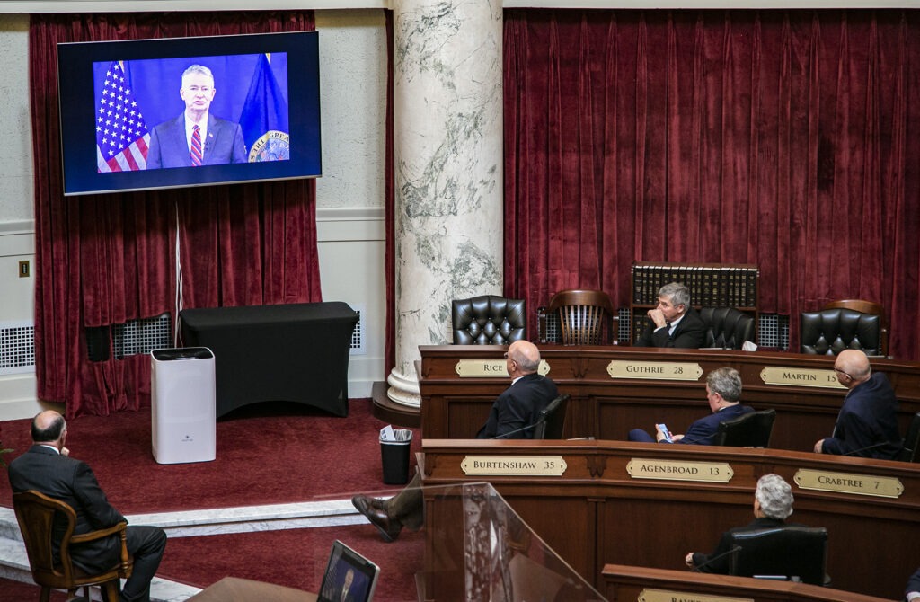 Senators watch Gov. Brad Little’s 2021 State of the State address from the floor of the Senate chambers. Because of COVID-19 precautions, Little delivered the address remotely instead of in the traditional joint gathering of the House and Senate chambers. CREDIT: Nik Streng/ Idaho EdNews