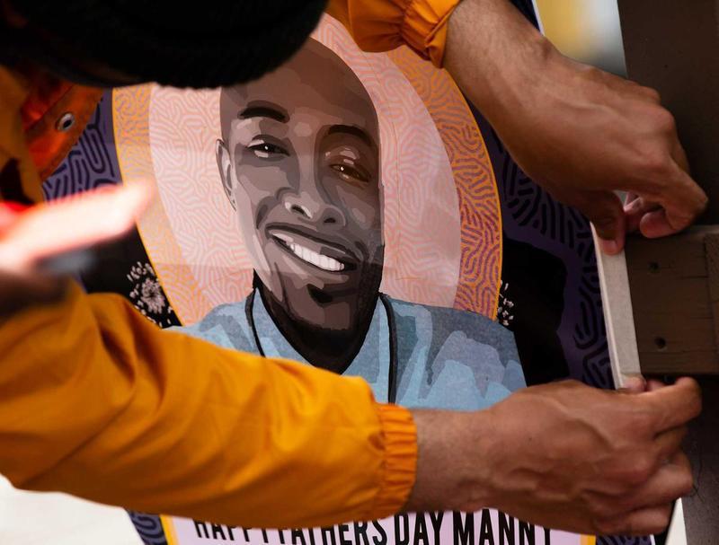 Community members gathered in June for a celebration of life for Manuel Ellis, who was killed by Tacoma police in March. In this photo, one of the attendees hangs a flyer with Ellis’ image that says “Happy Father’s Day Manny.” CREDIT: Parker Miles Blohm/KNKX