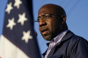 Raphael Warnock, a Democratic candidate for the U.S. Senate, speaks during a Nov. 15, 2020, campaign rally in Marietta, Ga., ahead of the Jan. 5, 2021 run-off election. As the head of the Atlanta church where Martin Luther King Jr. preached, Warnock did not shy away from impassioned sermons and forceful advocacy on behalf of the poor and disadvantaged. CREDIT: Brynn Anderson/AP
