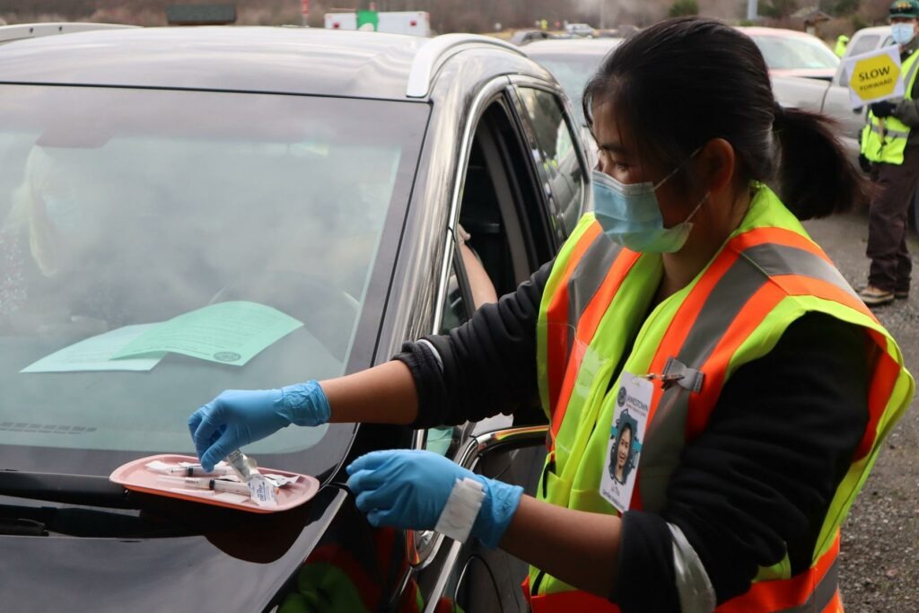 After an hours-long wait, drivers pull up under a vaccination tent to get their first dose of the Moderna COVID vaccine on Thursday, Jan. 14, 2021. CREDIT: Tom Banse/N3