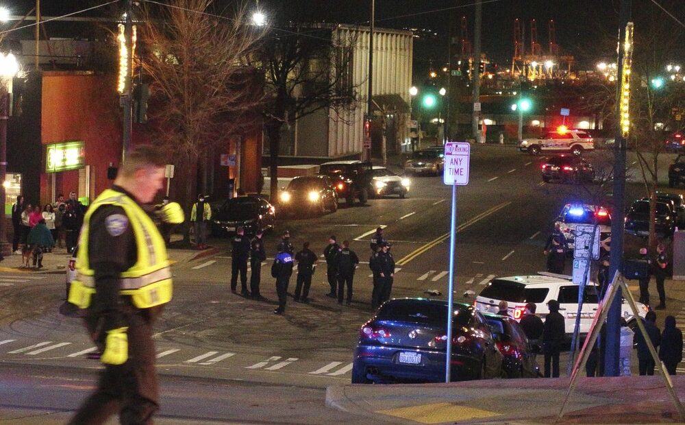 Tacoma Police and other law enforcement vehicles are shown near the site of a major incident Jan. 23, 2021, in downtown Tacoma. At least one person was injured when a police car driven by a Tacoma officer plowed through a crowd of people Saturday night who were watching a downtown street race. CREDIT: Ted S. Warren/AP