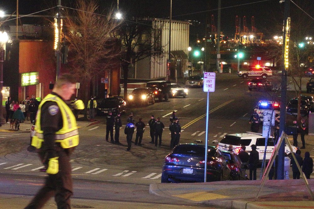 Tacoma Police and other law enforcement vehicles are shown near the site of a major incident Jan. 23, 2021, in downtown Tacoma. At least one person was injured when a police car driven by a Tacoma officer plowed through a crowd of people Saturday night who were watching a downtown street race. CREDIT: Ted S. Warren/AP