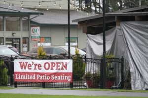 A sign at the El Sarape restaurant advertises outdoor seating, Jan. 5, 2021, in Olympia, Wash., as indoor dining was prohibited statewide due the the governor's coronavirus safety measures. CREDIT: Ted S. Warren/AP
