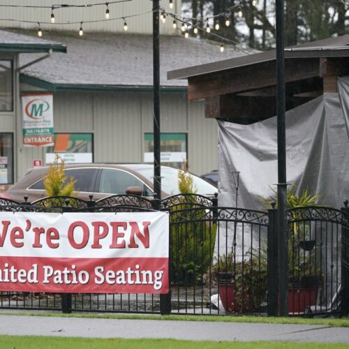 A sign at the El Sarape restaurant advertises outdoor seating, Jan. 5, 2021, in Olympia, Wash., as indoor dining was prohibited statewide due the the governor's coronavirus safety measures. CREDIT: Ted S. Warren/AP