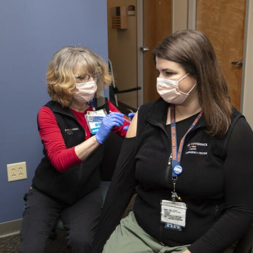 Nurse Elizabeth Vadnais administers the COVID-19 vaccine to fellow nurse Ashlynn Strode. Courtesy of Providence of SW Washington