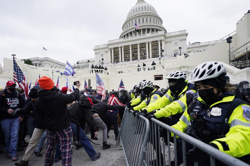 Trump supporters try to break through a police barrier at the Capitol in Washington, D.C., on Wednesday. As Congress prepares to affirm President-elect Joe Biden's victory, thousands of people have gathered to show their support for President Trump. CREDIT: John Minchillo/AP