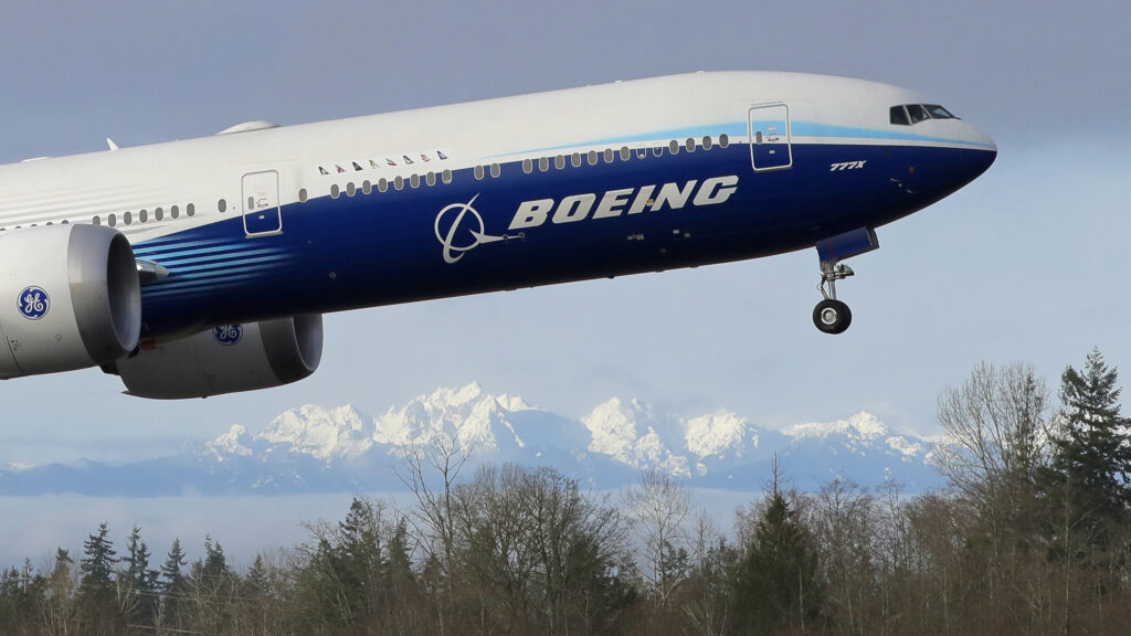 Boeing 777-X jet takes off in Seattle with Olympia Mountains in the background