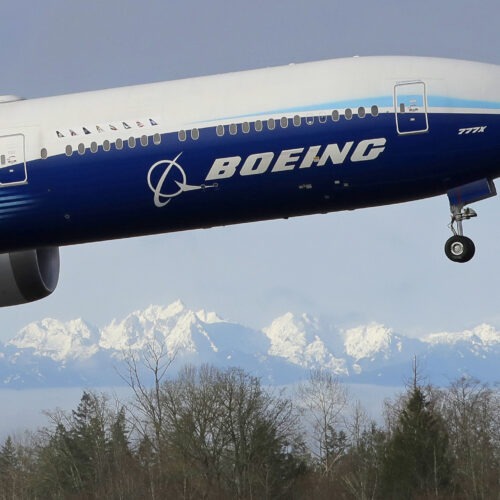 Boeing 777-X jet takes off in Seattle with Olympia Mountains in the background