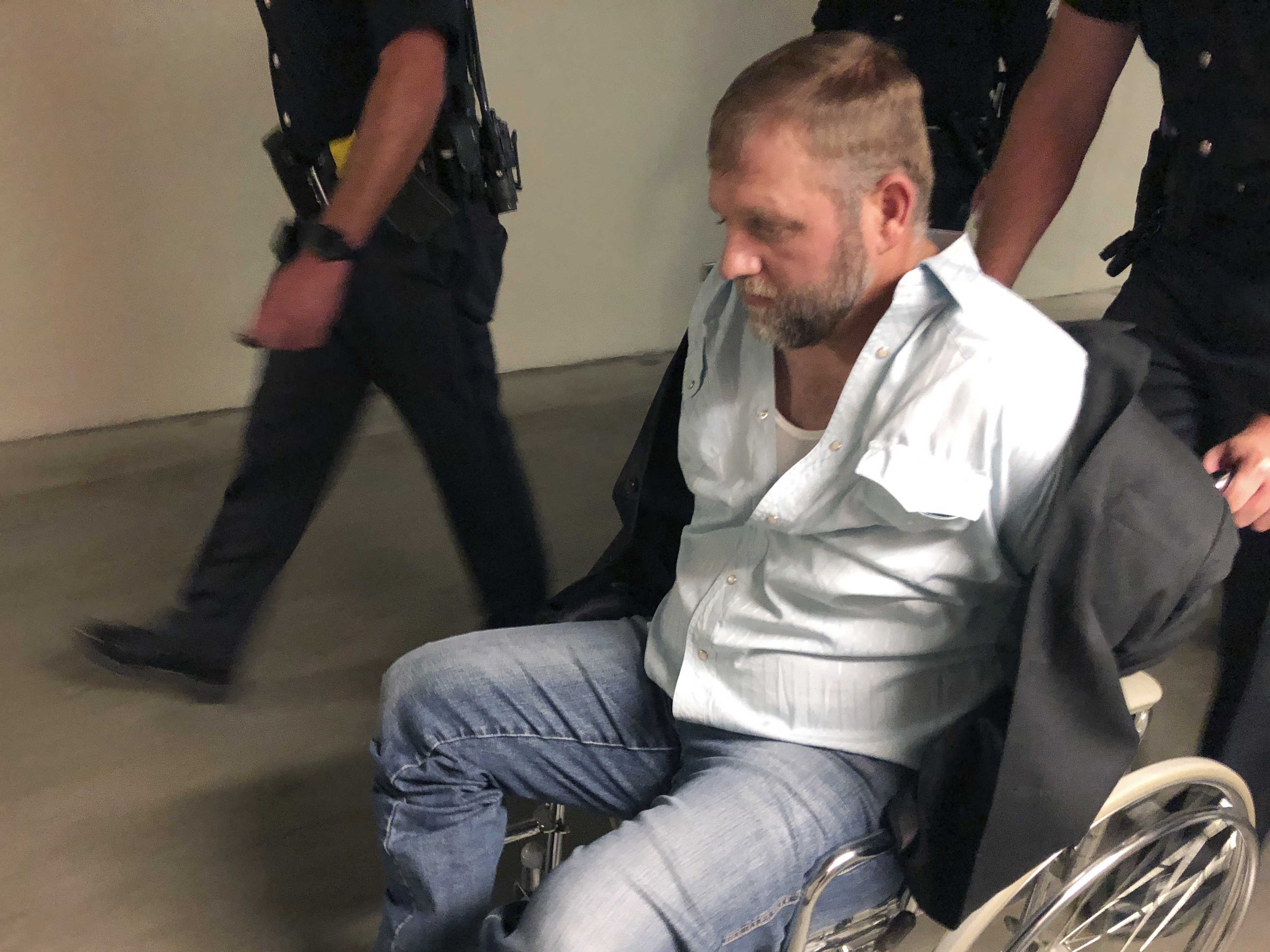 Anti-government activist Ammon Bundy is wheeled from the Idaho Statehouse in Boise, on Aug. 26, 2020. It was his second arrest for trespassing in two days. CREDIT: Keith Ridler/AP