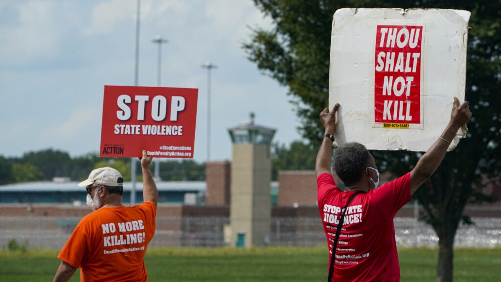 Protesters gather near the federal prison complex in Terre Haute, Ind., in August ahead of the scheduled execution of Keith Dwayne Nelson, who was convicted of kidnapping, raping and murdering at 10-year-old Kansas girl. Democrats are pushing new legislation to outlaw federal executions. CREDIT: Michael Conroy/AP