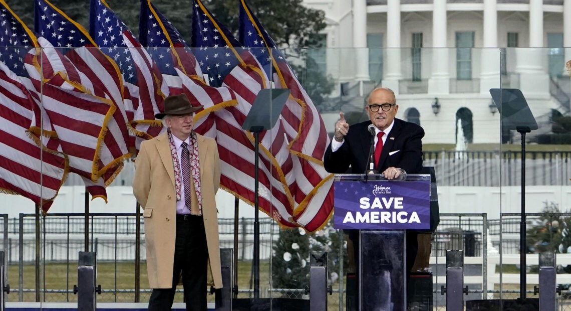 Rudy Giuliani, seen here on Jan. 6 with Chapman University law professor John Eastman, speaks in Washington at a rally in support of former President Donald Trump. Dominion Voting Systems, a frequent target of Giuliani, is suing him for defamation. CREDIT: Jacquelyn Martin/AP