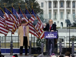 Rudy Giuliani, seen here on Jan. 6 with Chapman University law professor John Eastman, speaks in Washington at a rally in support of former President Donald Trump. Dominion Voting Systems, a frequent target of Giuliani, is suing him for defamation. CREDIT: Jacquelyn Martin/AP