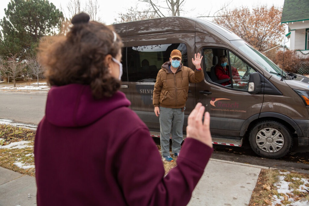 Suzan Mubarak visits with her boyfriend, Mitch Domier, from a distance during a weekly drive-by visit outside Mubarak’s group home in Bozeman, Montana, on Dec. 20, 2020. They don’t talk long — that’s saved for their nightly video chats, the only place they see each other's face without a mask. (Louise Johns for KHN)