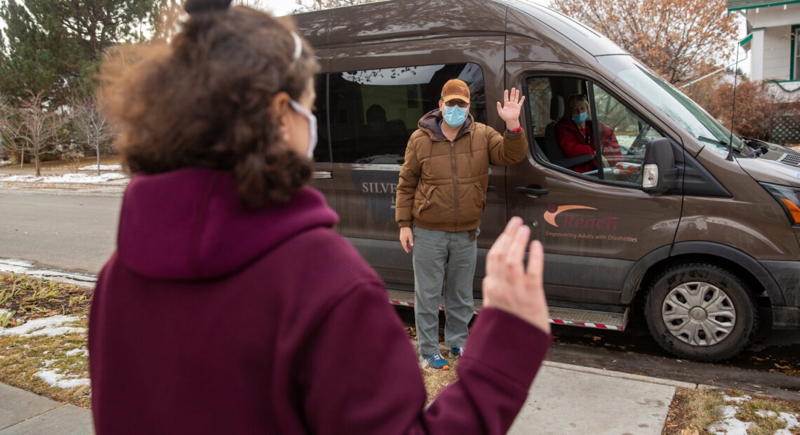 Suzan Mubarak visits with her boyfriend, Mitch Domier, from a distance during a weekly drive-by visit outside Mubarak’s group home in Bozeman, Montana, on Dec. 20, 2020. They don’t talk long — that’s saved for their nightly video chats, the only place they see each other's face without a mask. (Louise Johns for KHN)
