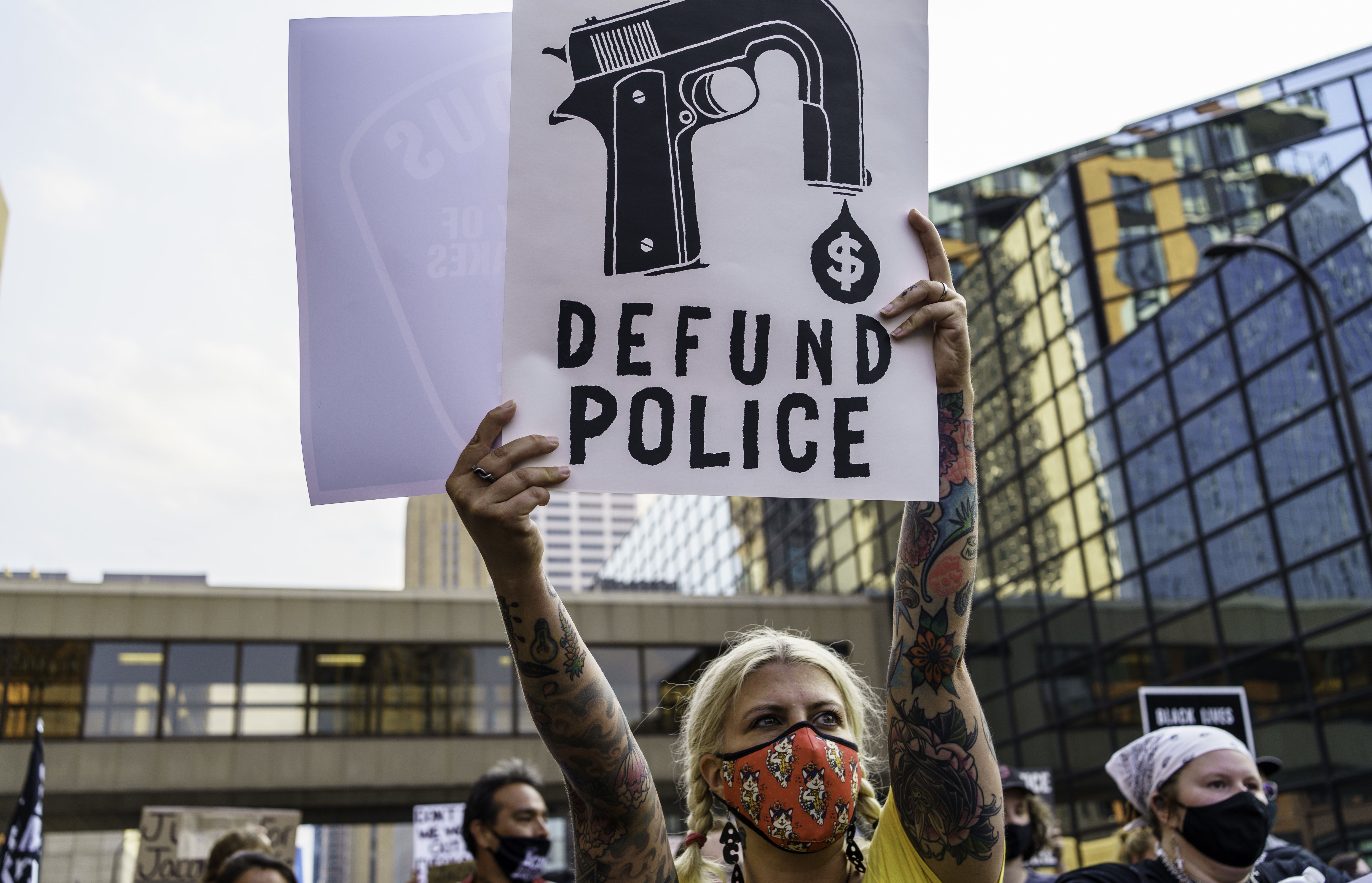 A protester hold a sign reading "Defund the Police" outside Hennepin County Government Plaza during a demonstration against police brutality and racism on Aug. 24, 2020, in Minneapolis. Kerem Yucel/AFP via Getty Images