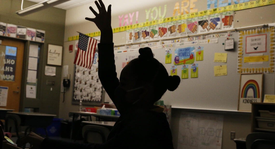 A first-grader raises her hand at Mary L. Fonseca Elementary School in Fall River, Mass., in November. Jessica Rinaldi/Boston Globe via Getty Images