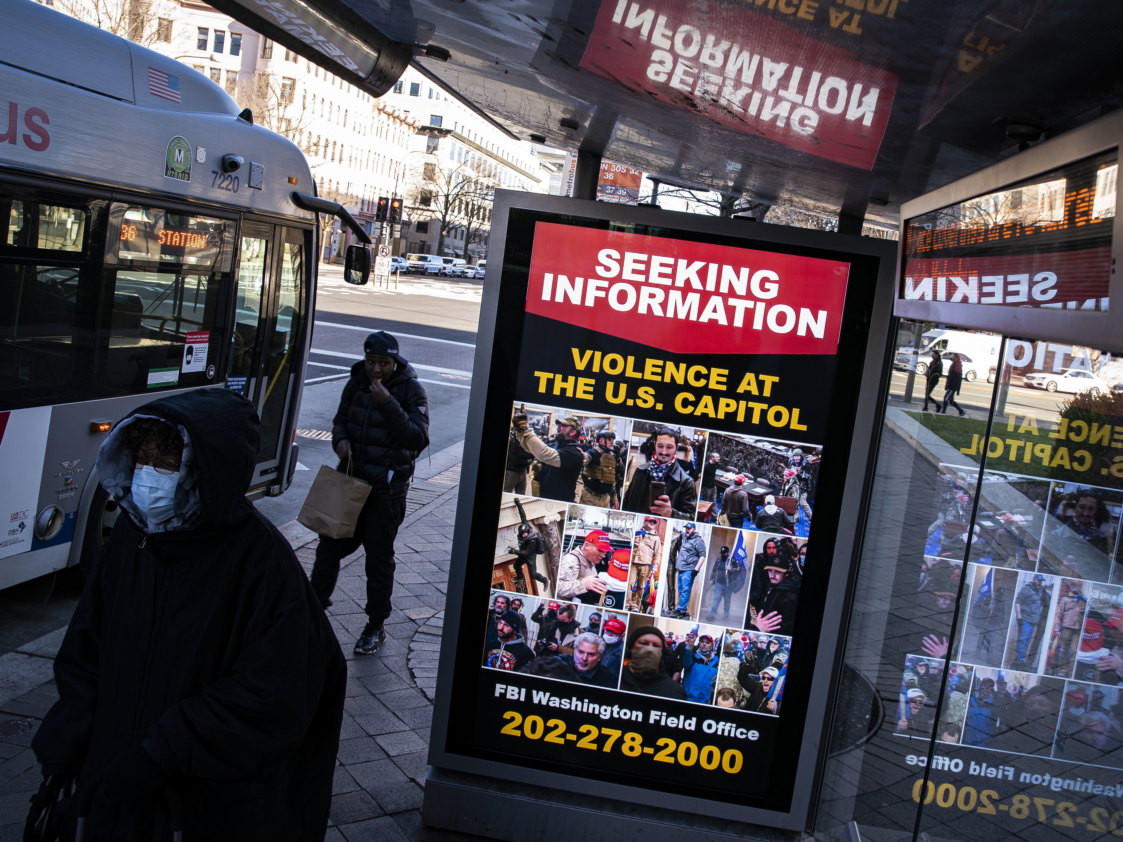 At a bus stop on Pennsylvania Avenue Northwest in Washington, D.C., a notice from the FBI seeks information about people pictured during the riot at the U.S. Capitol on Wednesday, Jan. 6, 2021. CREDIT: Al Drago/Getty Images