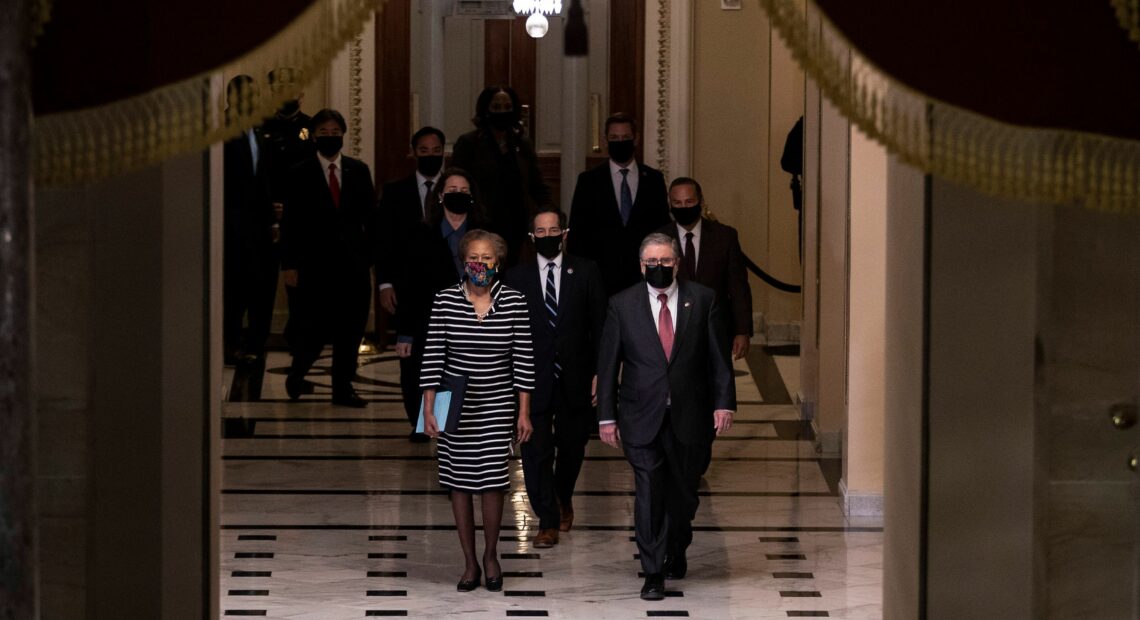 L-R: U.S. House Clerk Cheryl Johnson, Rep. Jamie Raskin and Rep. David Cicilline walk walk through the Capitol's Statuary Hall to deliver the article of impeachment for incitement of insurrection against former President Trump to the Senate floor on Monday evening. Tasos Katopodis/Pool/AFP via Getty Images