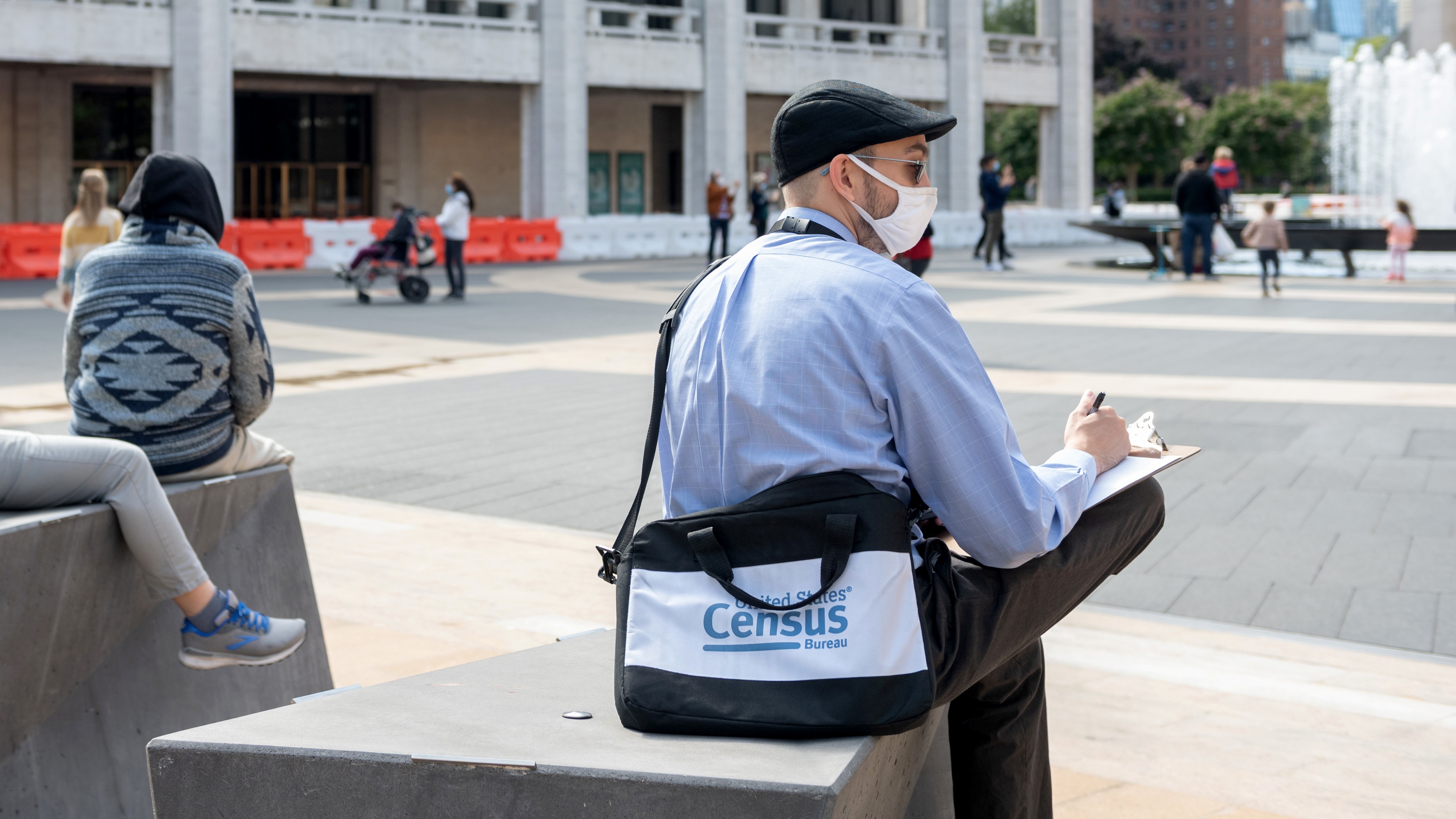 A U.S. census worker sits in the plaza of the Lincoln Center for the Performing Arts in New York City in September. The Census Bureau announced Wednesday that the first results of the 2020 census are expected to be released by April 30. CREDIT: Alexi Rosenfeld/Getty Images