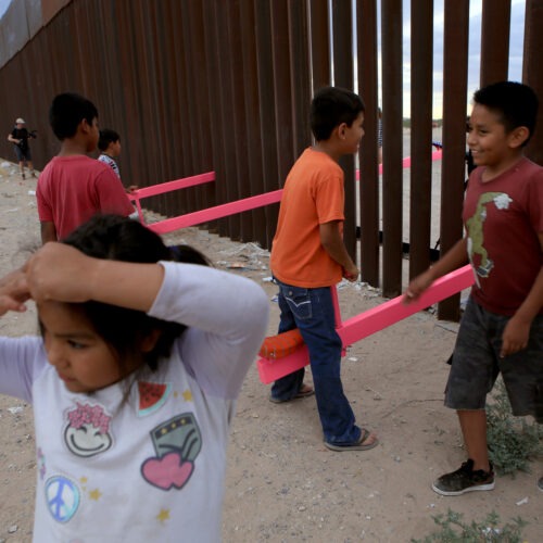 American and Mexican families play with a see-saw installation at the border near Ciudad Juarez, Mexico, in July of 2019. The project has been recognized by a prestigious design award. Luis Torres/AFP via Getty Images