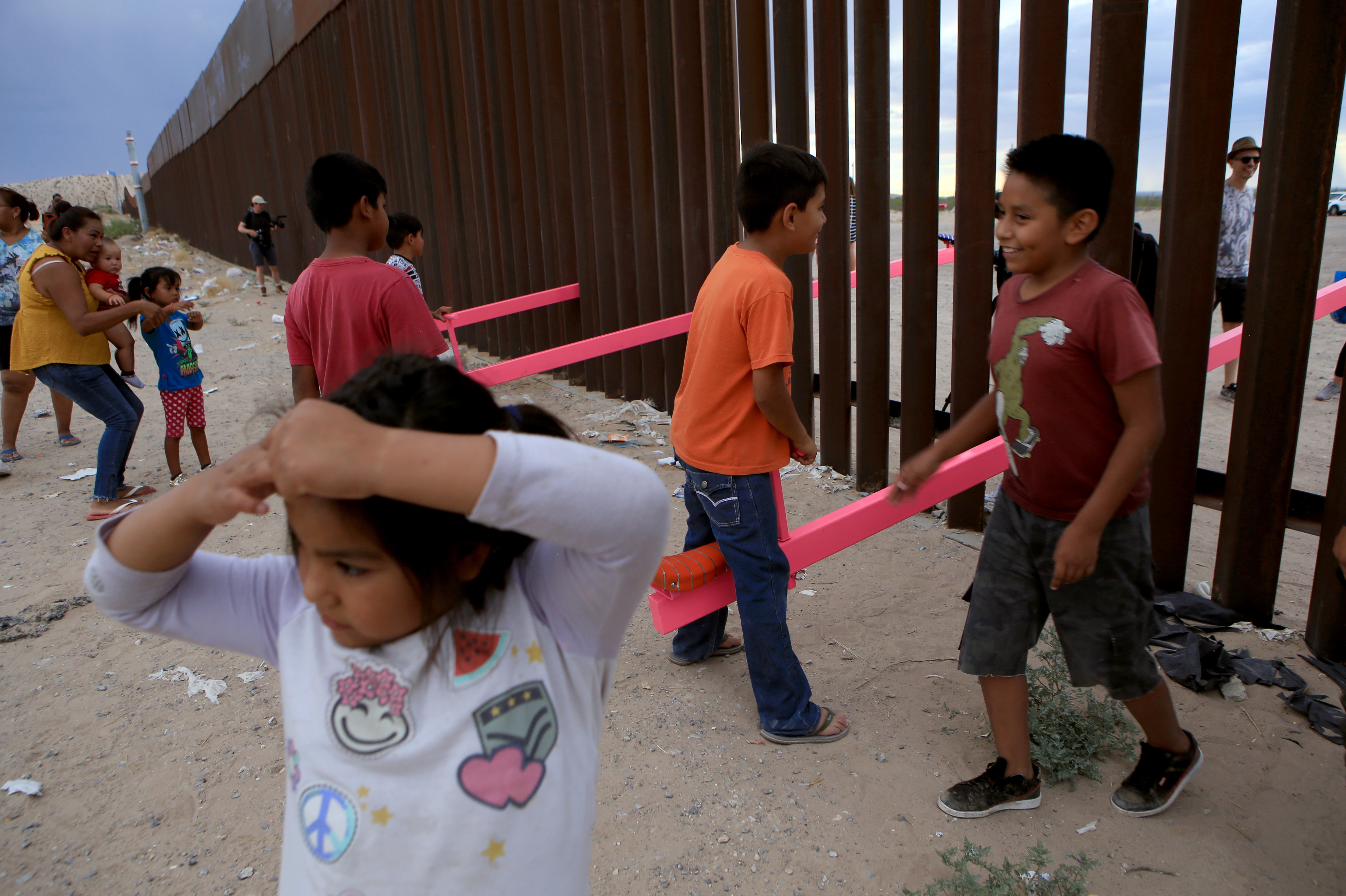 American and Mexican families play with a see-saw installation at the border near Ciudad Juarez, Mexico, in July of 2019. The project has been recognized by a prestigious design award. Luis Torres/AFP via Getty Images