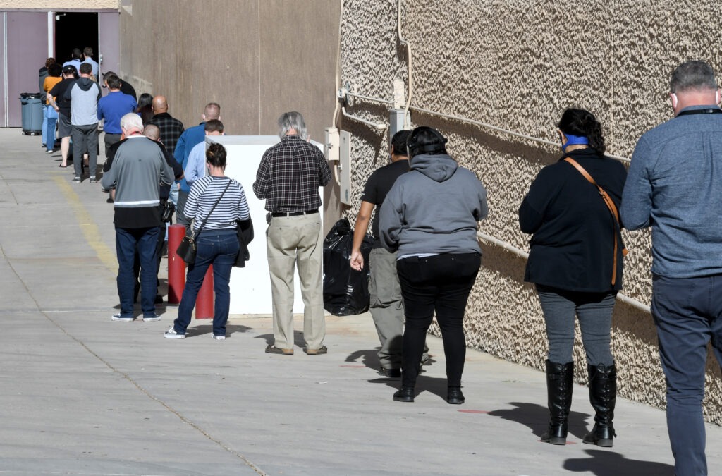 People line up on Thursday for the first day of Clark County's pilot COVID-19 vaccination program at Cashman Center in Las Vegas. CREDIT: Ethan Miller/Getty Images