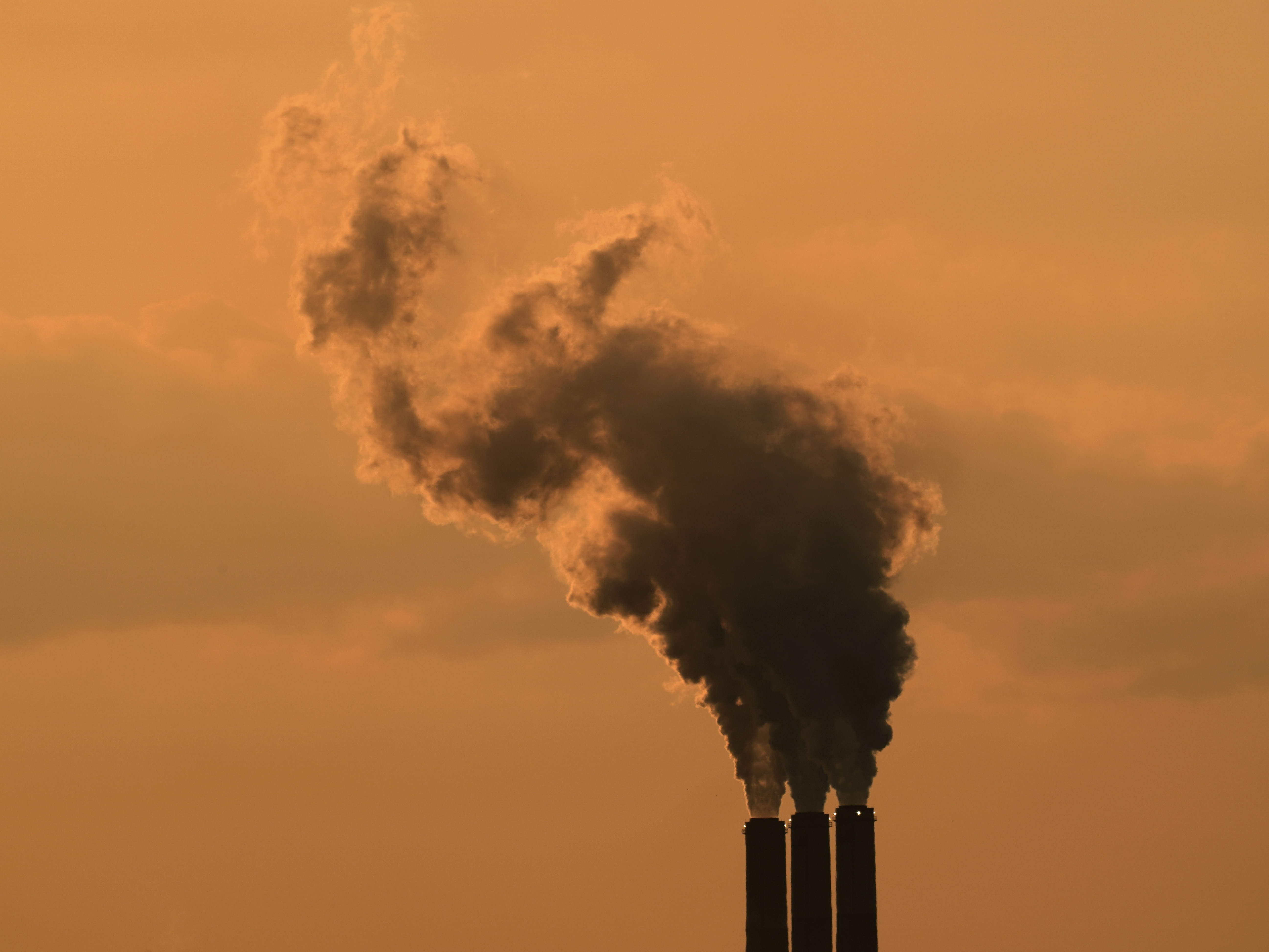 Smokestacks at the Jeffrey Energy Center coal-fired power plant are silhouetted against the sky at sunset in September near Emmet, Kan. CREDIT: Charlie Riedel/AP