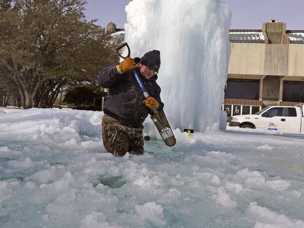 City of Richardson worker Kaleb Love breaks ice on a frozen fountain Tuesday, Feb. 16, 2021, in Richardson, Texas. Temperatures dropped into the single digits as snow shut down air travel and grocery stores. CREDIT: AP Photo/LM Otero