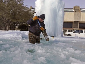 City of Richardson worker Kaleb Love breaks ice on a frozen fountain Tuesday, Feb. 16, 2021, in Richardson, Texas. Temperatures dropped into the single digits as snow shut down air travel and grocery stores. CREDIT: AP Photo/LM Otero