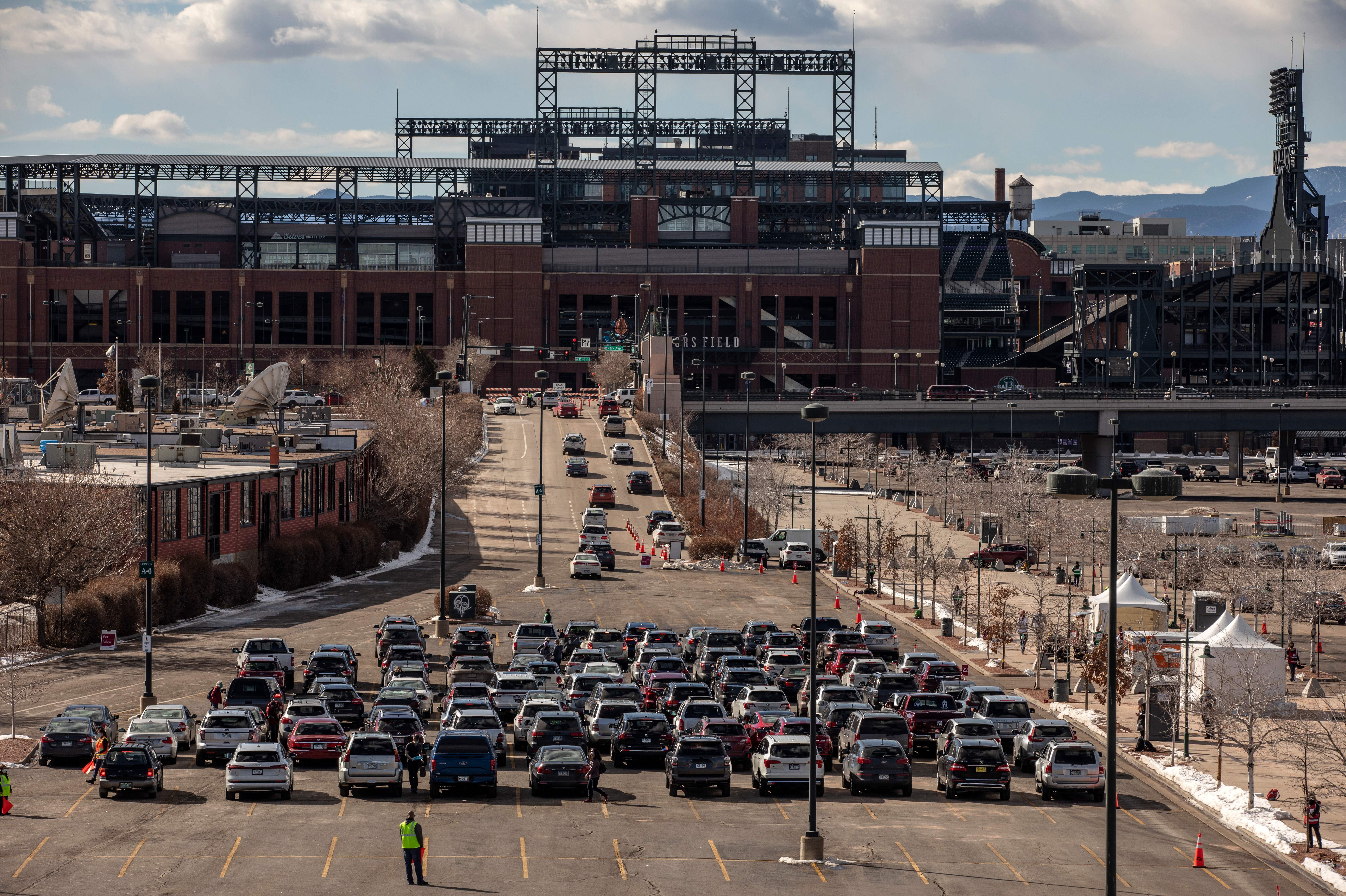 People line up for drive-through COVID-19 vaccination at Coors Field baseball stadium in Denver on Saturday, Jan. 30, 2021. Chet Strange/AFP via Getty Images