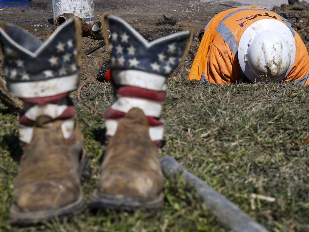 A worker fixes a water pipe in Galveston, Texas, on Feb. 19. The power is back on in much of the state, but the Lone Star State now faces the hefty cost of emerging from its devastating storms. Thomas Shea/AFP via Getty Images