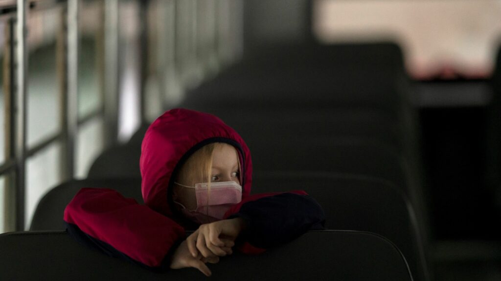 A first-grade student sits on the bus after a day of classes in Woodland, Wash., on Thursday. Nathan Howard/Getty Images