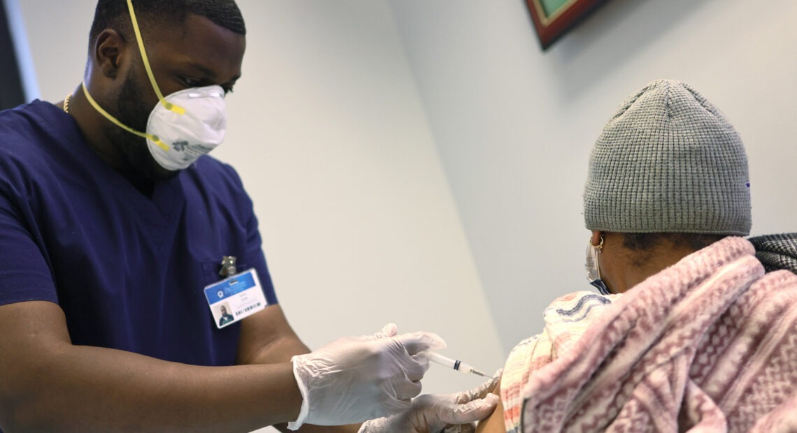 Kurtis Smith gives the Moderna coronavirus vaccine to a resident at Red Hook Neighborhood Senior Center in Brooklyn, N.Y., on Monday. CREDIT: Michael M. Santiago/Getty Images