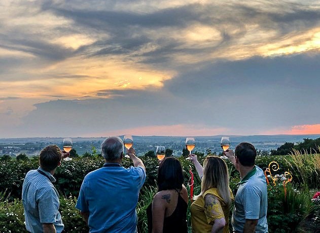 People toasting the sunset with wine glasses outside in Washington state